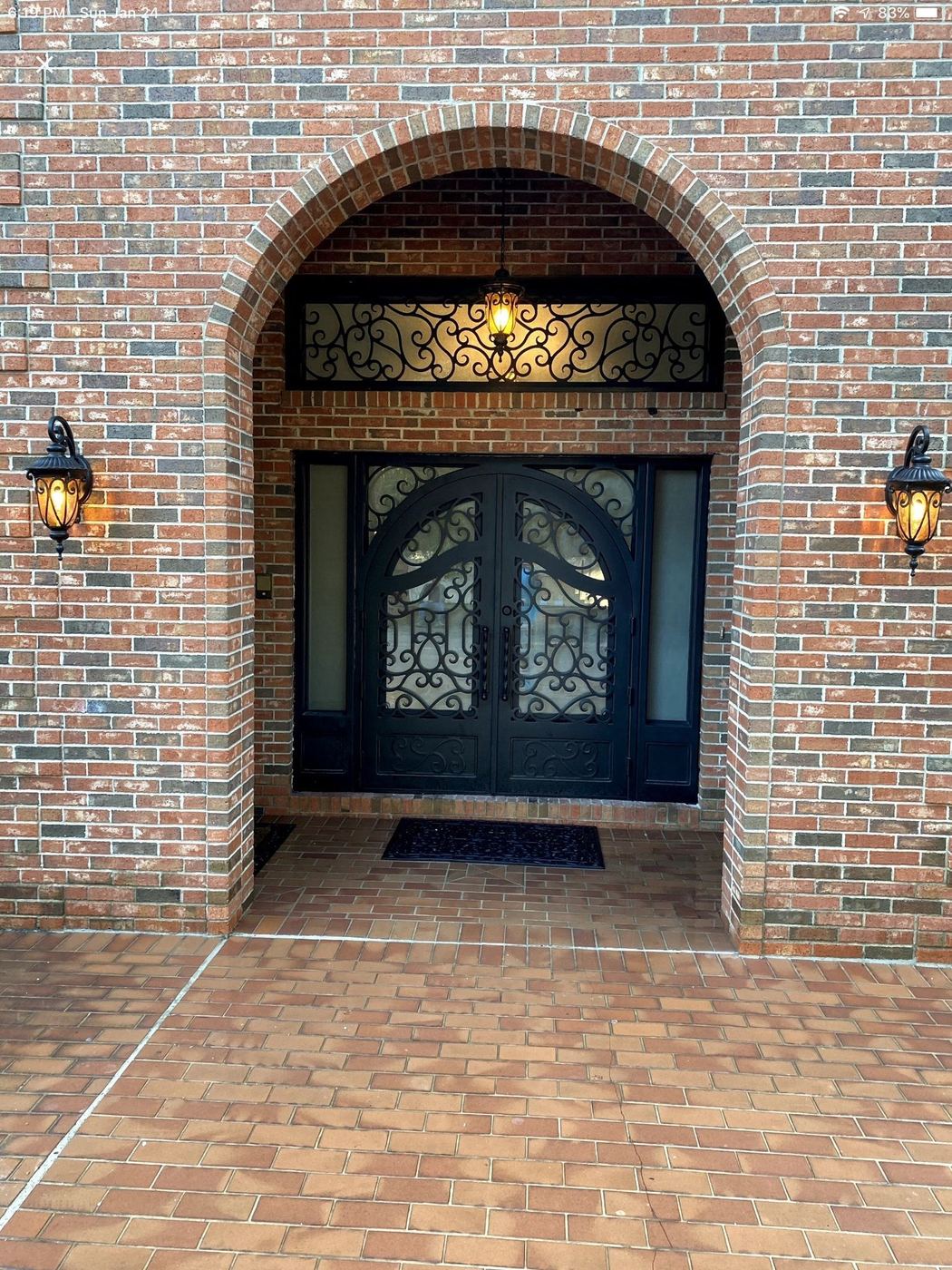 Arched iron entry doors in brick